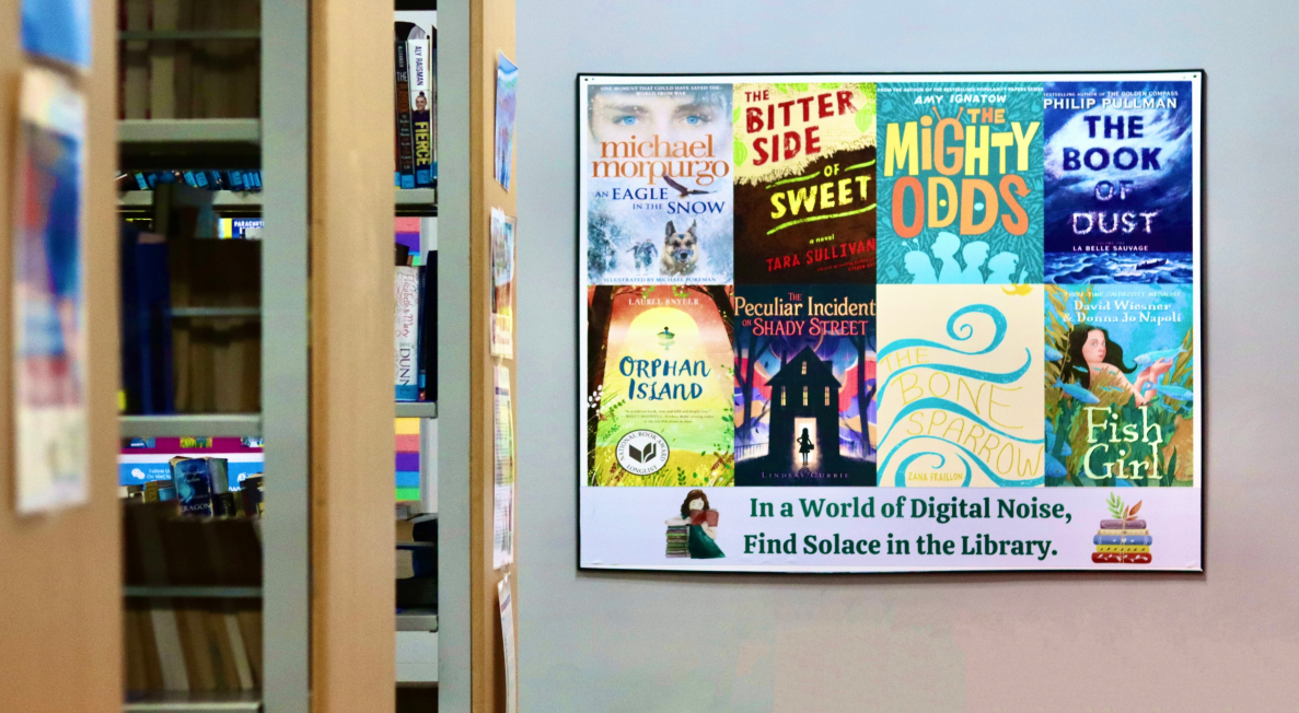 A woman with blonde hair and a white shirt is smiling while using a laptop.