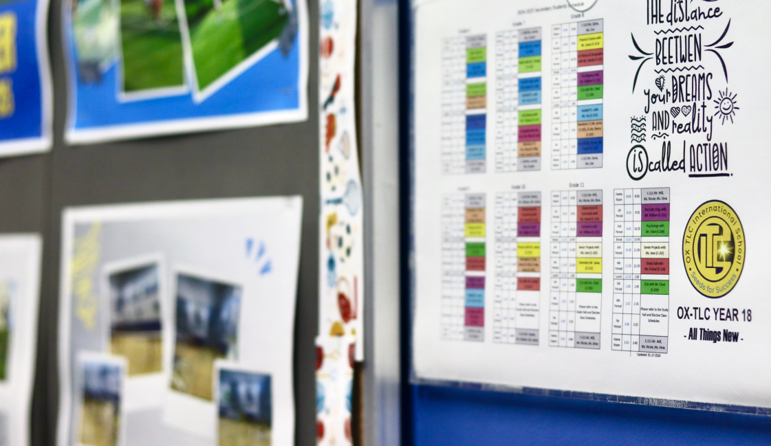 A woman with glasses and a pink shirt is teaching a class.